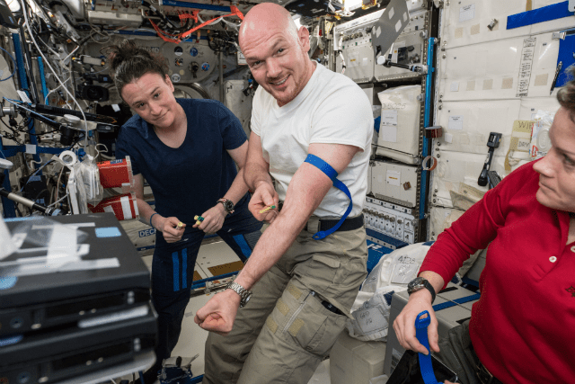 image of astronauts Alexander Gerst and Serena Auñón-Chancellor collecting blood samples from themselves inside ISS